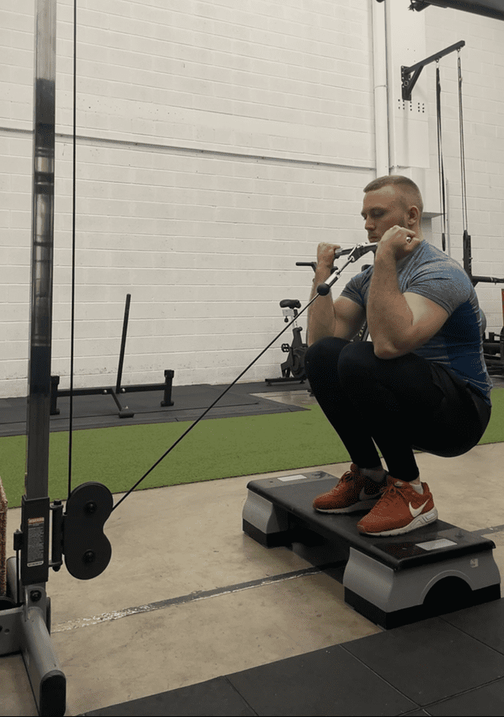 aleksander saks perfroming squatting cable curls